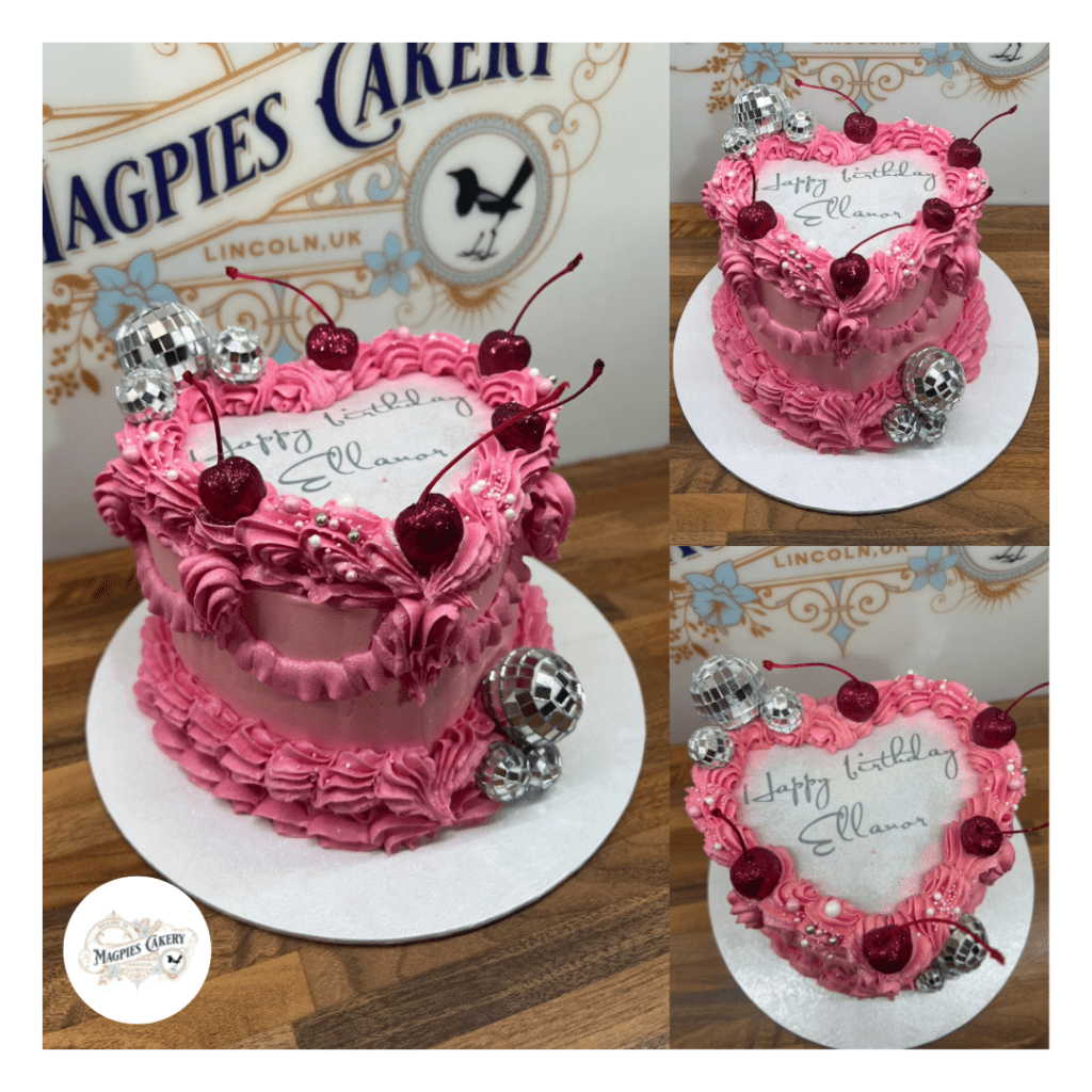 Vintage style heart pink buttercream finish birthday cake with cherries & disco balls. Magpies Cakery, cake maker & decorator, Lincoln & Newark UK